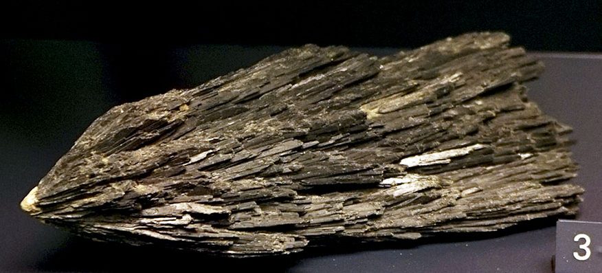 Black kyanite fan-shaped blade cluster on dark background