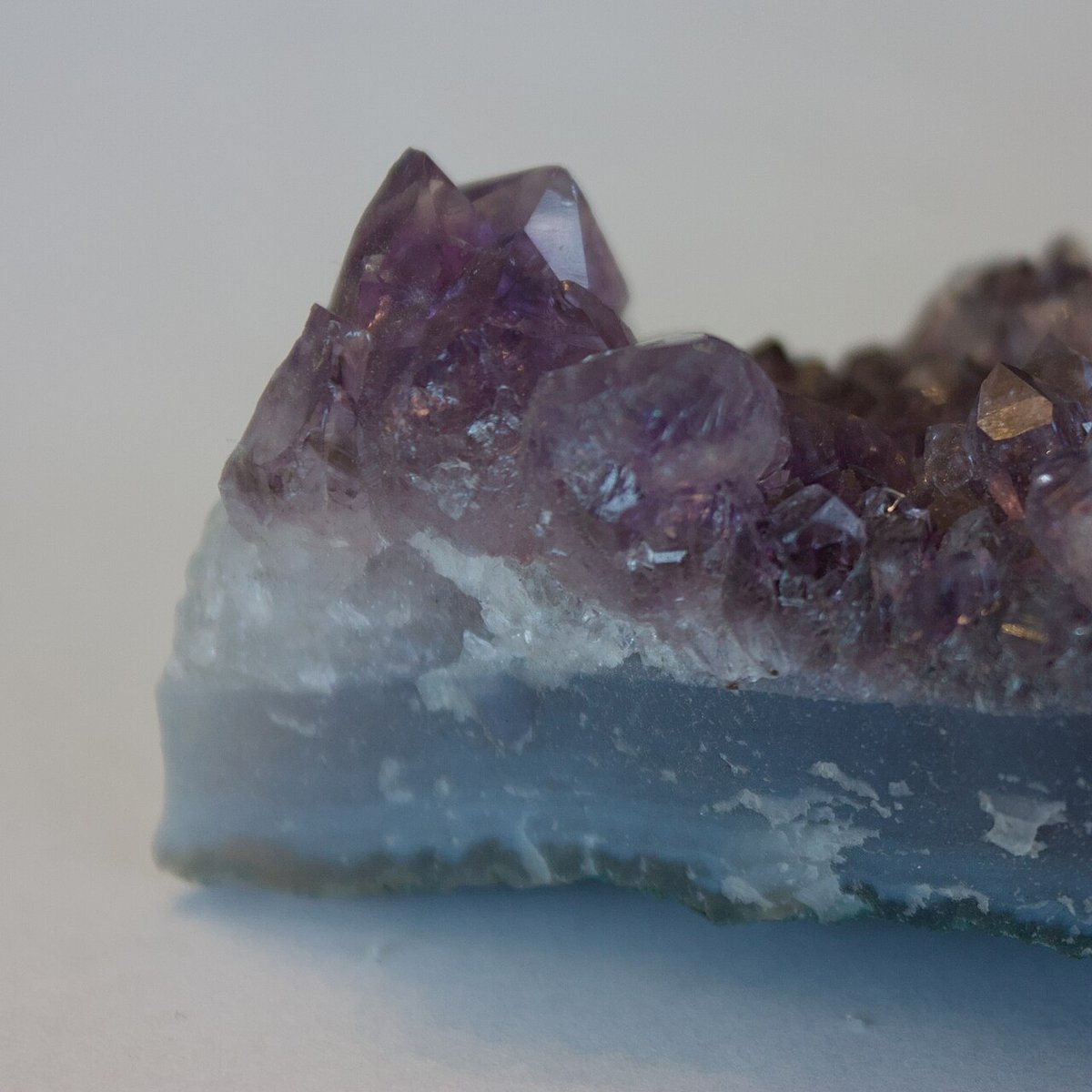 Polished blue chalcedony cabochon showing soft sky blue color with subtle banding on neutral background