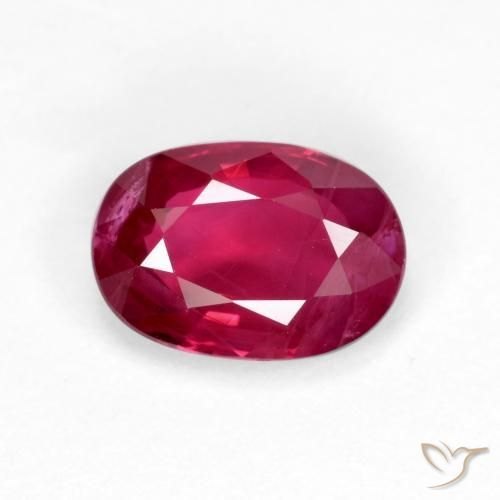 Burmese ruby faceted oval gemstone showing vivid red pigeon blood color on neutral background