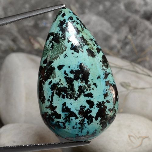 Polished chrysocolla cabochon showing turquoise-blue and green swirls on neutral background