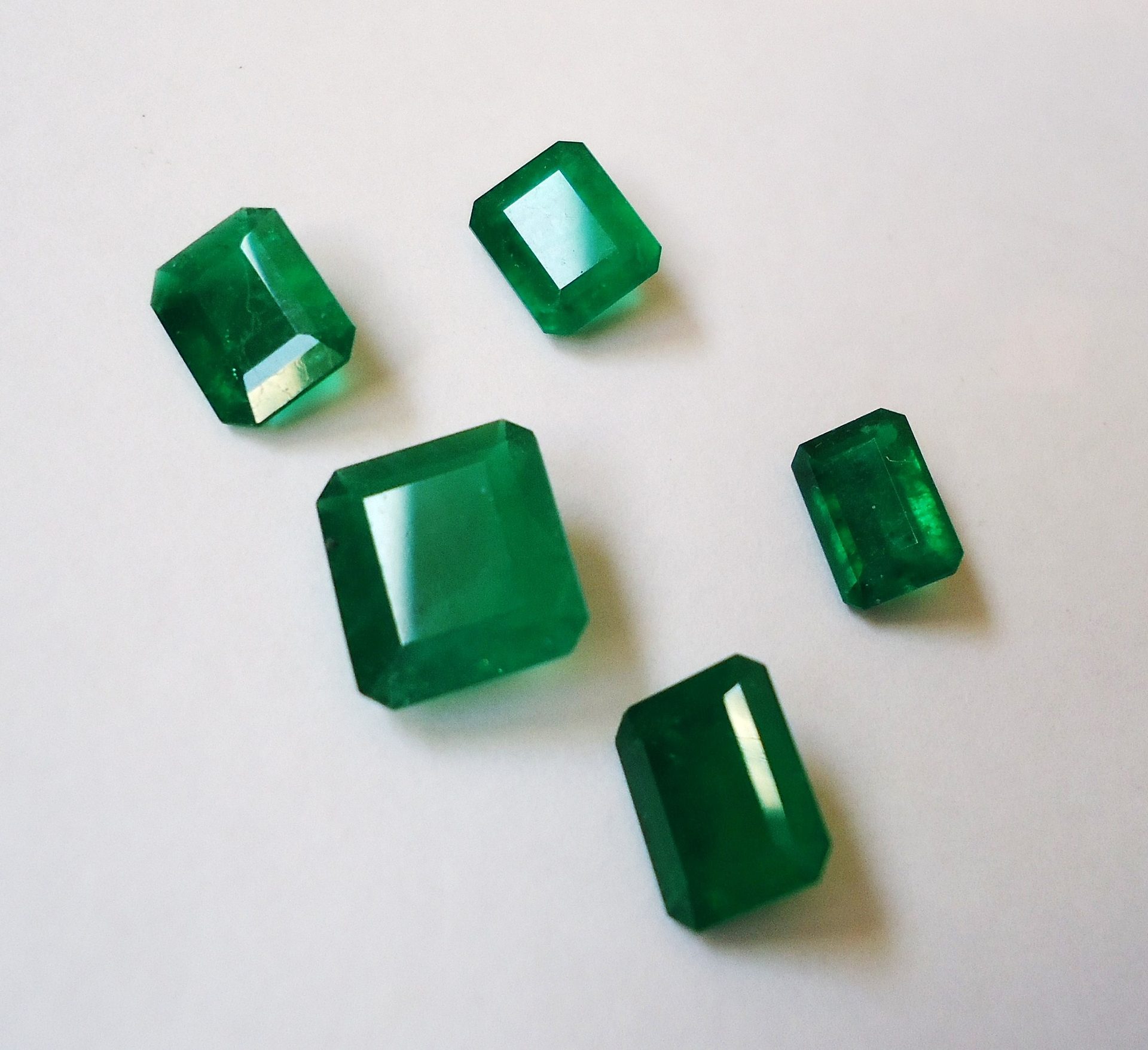 Faceted Colombian emerald showing vivid grass-green color with characteristic jardin inclusions