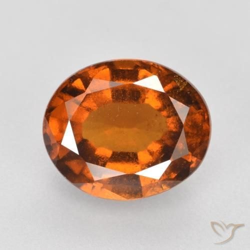 Faceted brown enstatite gemstone on neutral background showing magnesium silicate color