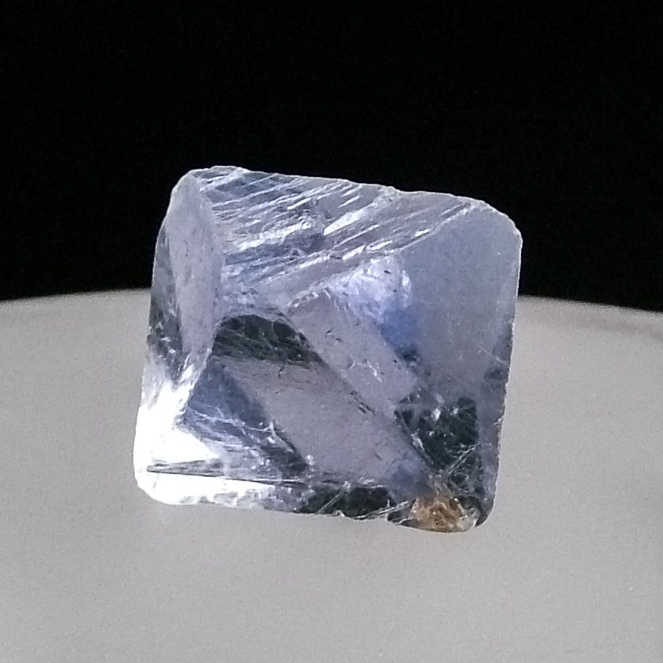 Natural fluorite octahedron cleavage piece showing eight perfect triangular faces