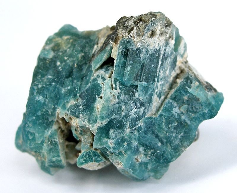 Faceted grandidierite gemstone showing translucent blue-green color on neutral background