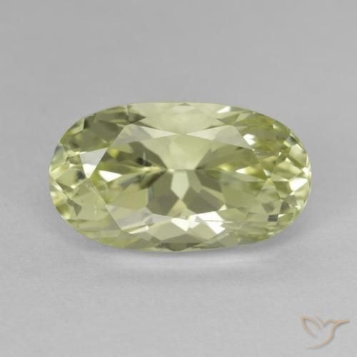 Faceted green hiddenite spodumene gemstone on neutral background