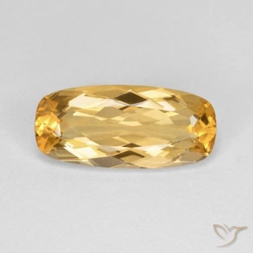 Faceted imperial topaz gemstone showing sherry orange color on neutral background