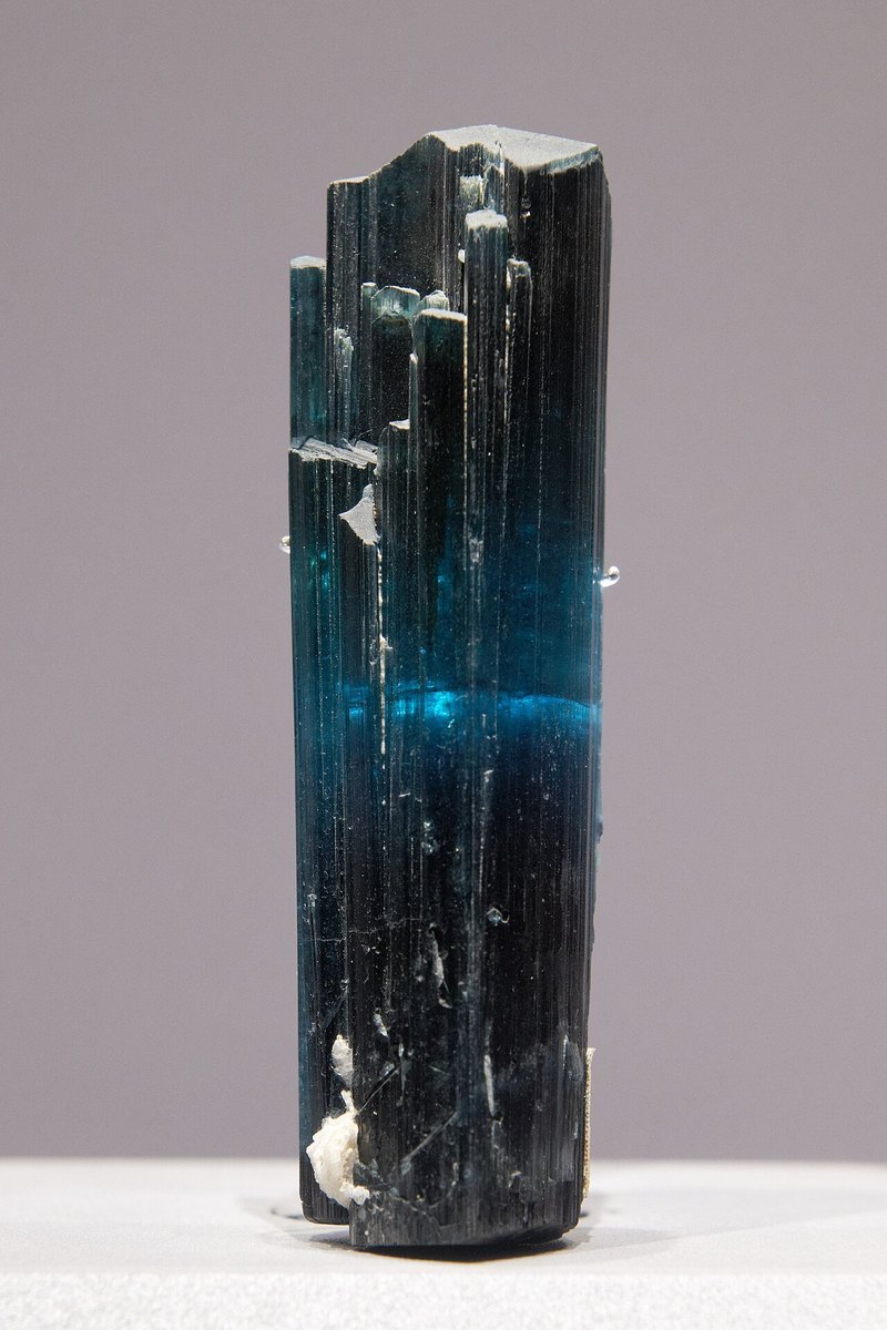 Faceted indicolite blue tourmaline showing rich teal-blue color and brilliant luster on neutral background