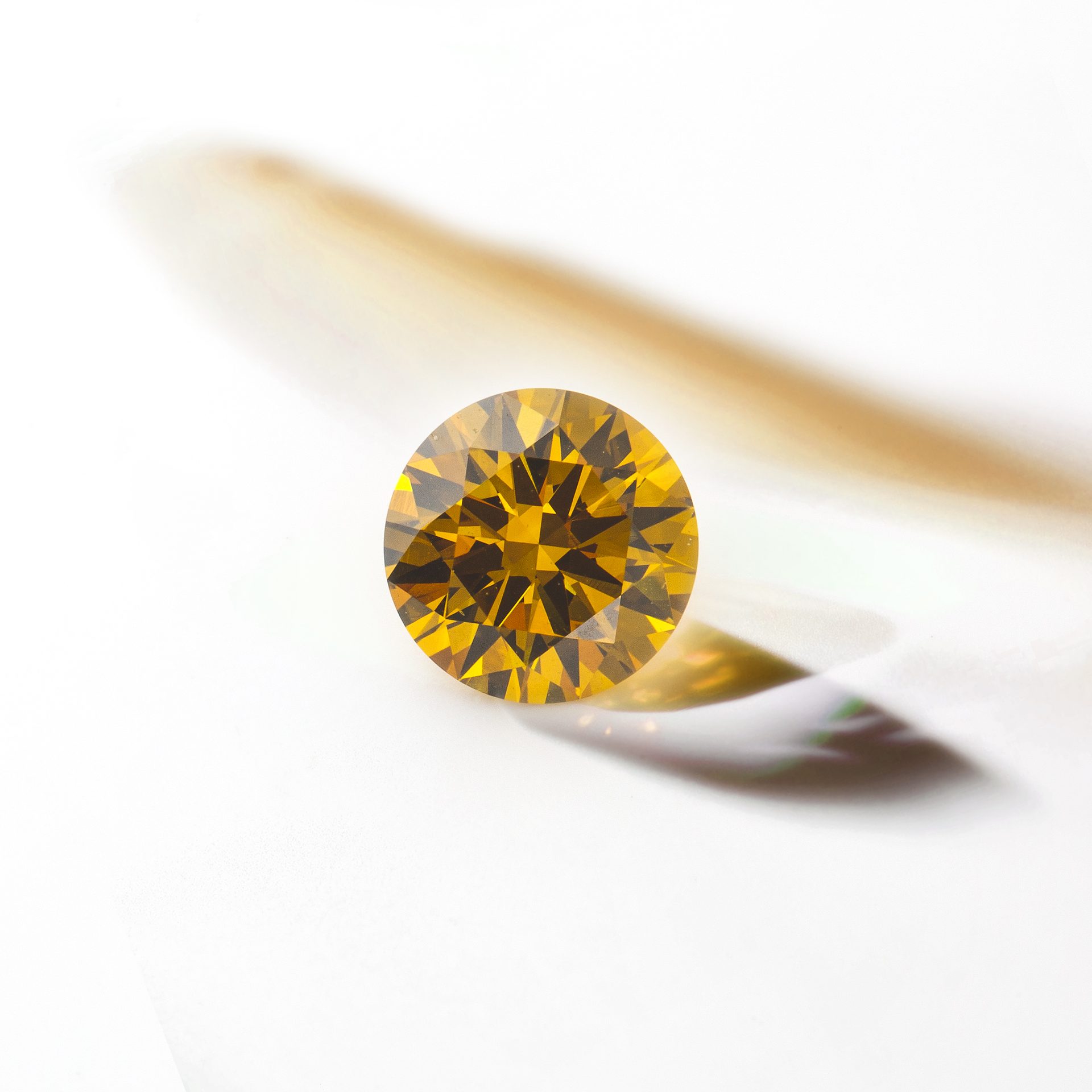 Lab Created Diamond round brilliant faceted showing extraordinary fire and brilliance against white background