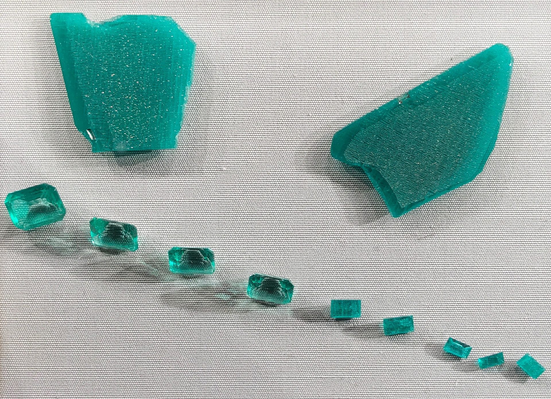 Lab Created Emerald faceted gemstone showing vivid green color against white background