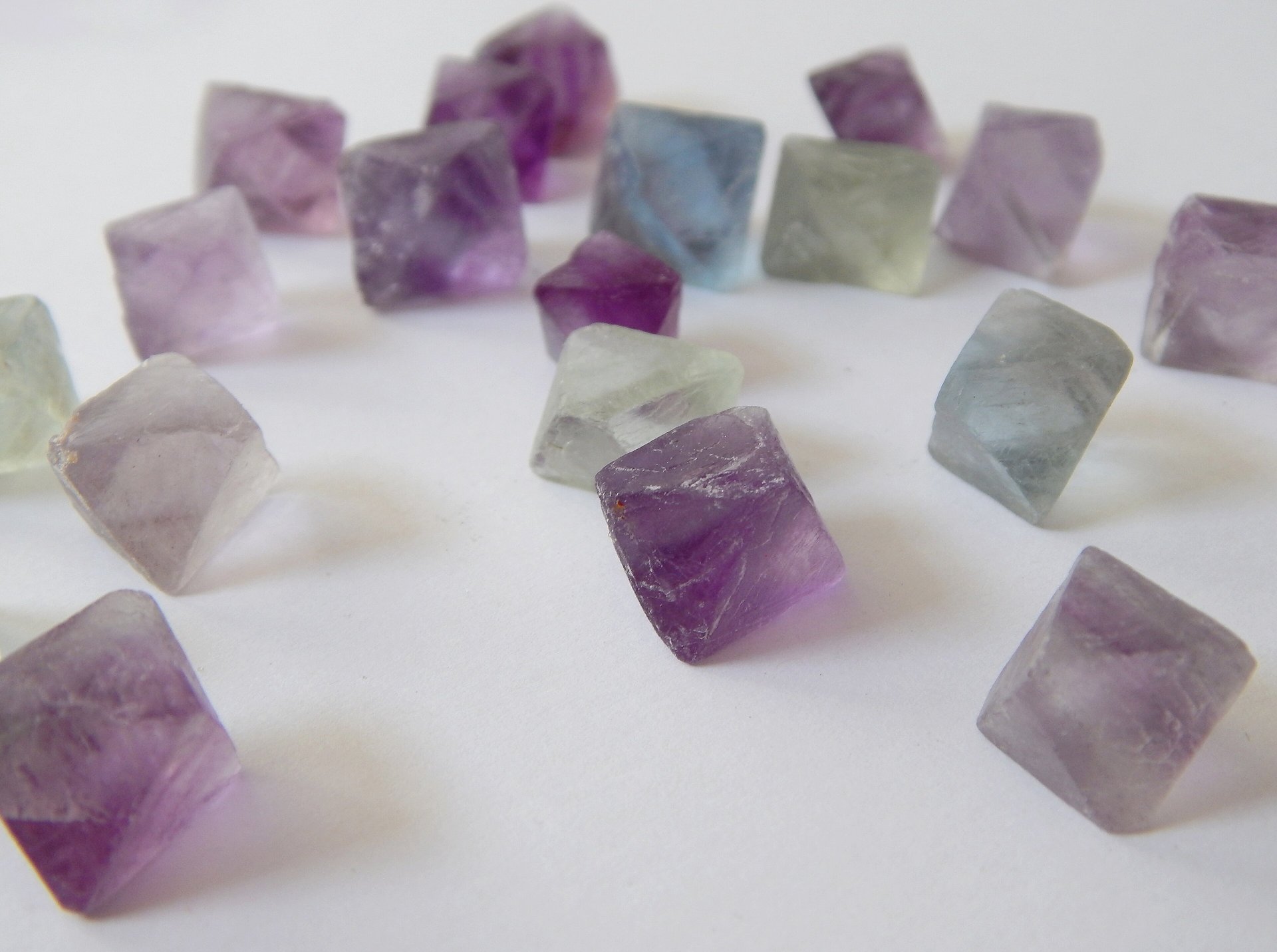 Deep purple fluorite octahedron crystal on white background
