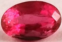 Faceted red beryl bixbite raspberry red crystal from Utah Wah Wah Mountains on neutral background
