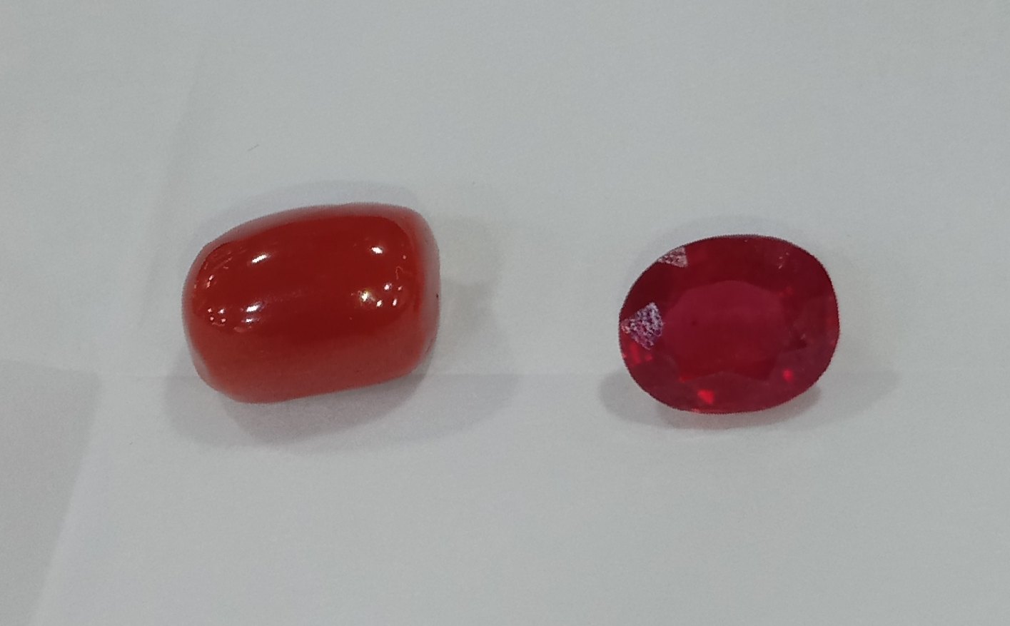 Polished red Mediterranean coral cabochon showing deep saturated coral red on neutral background