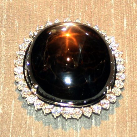 Blue star sapphire cabochon showing 6-ray asterism star on dark background