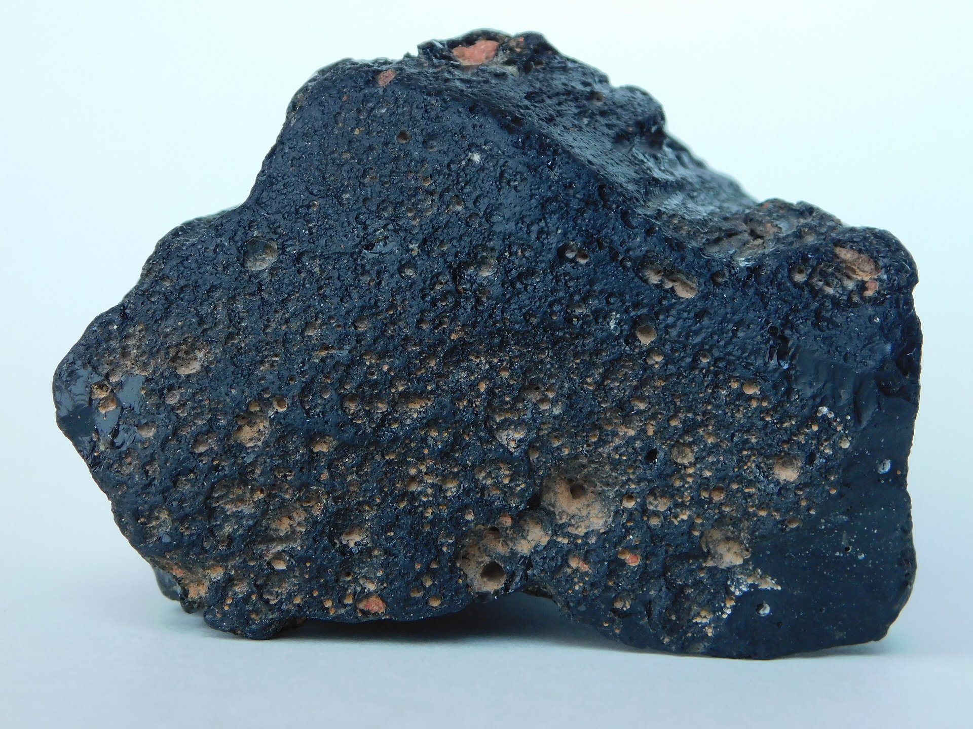 Black tektite natural specimen showing aerodynamic shape and glassy surface