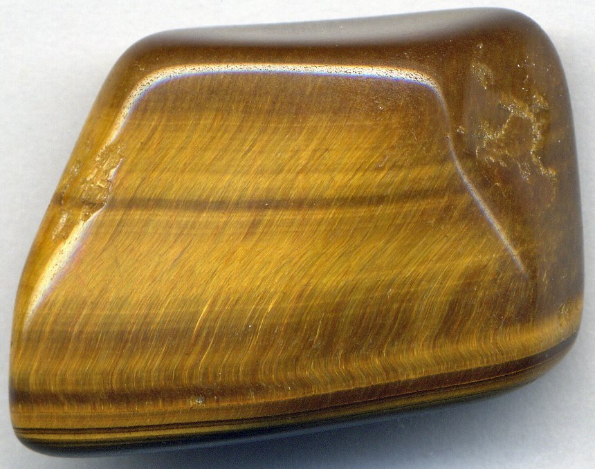 Polished tiger iron cabochon showing gold tiger eye, red jasper, and silver hematite bands on neutral background
