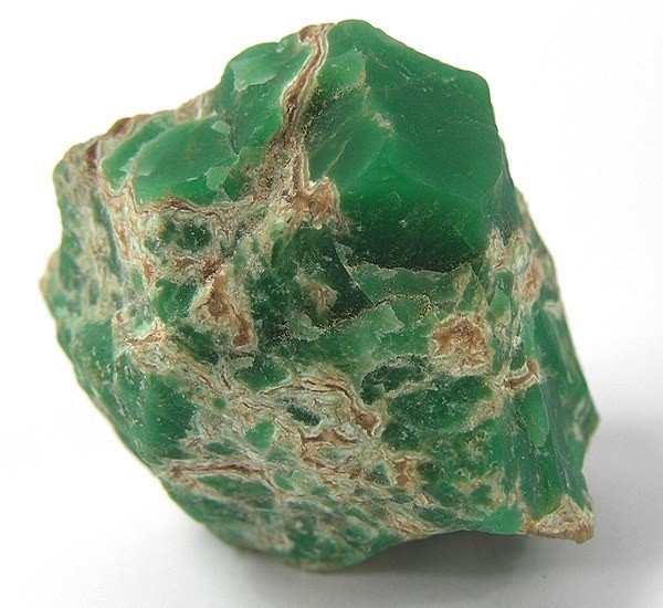 Polished variscite cabochon showing pale green color with brown matrix on neutral background