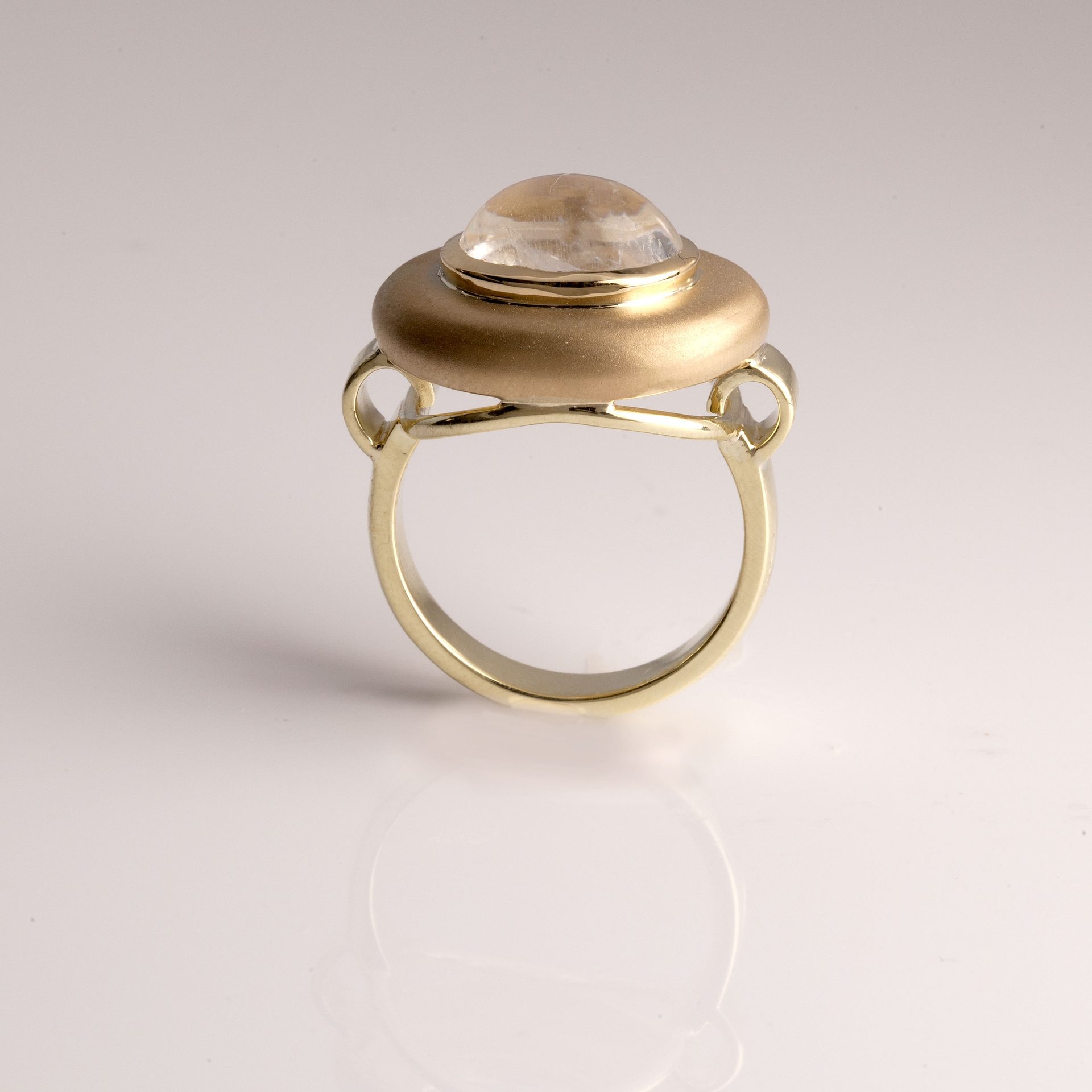 Yellow moonstone cabochon showing warm golden adularescent glow on peach-yellow feldspar base